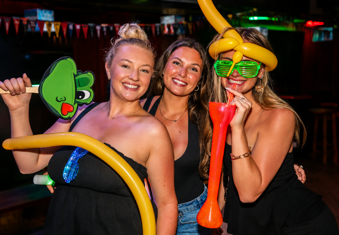 Amigas con globos y lentes de fiesta en Señor Frog’s Pensacola Beach