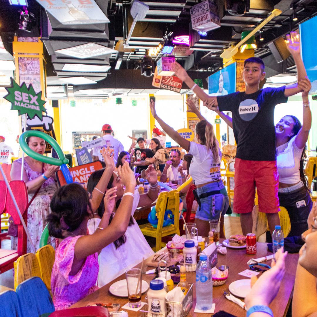 Invitados celebrando alrededor de una mesa larga en Señor Frog’s Playa del Carmen