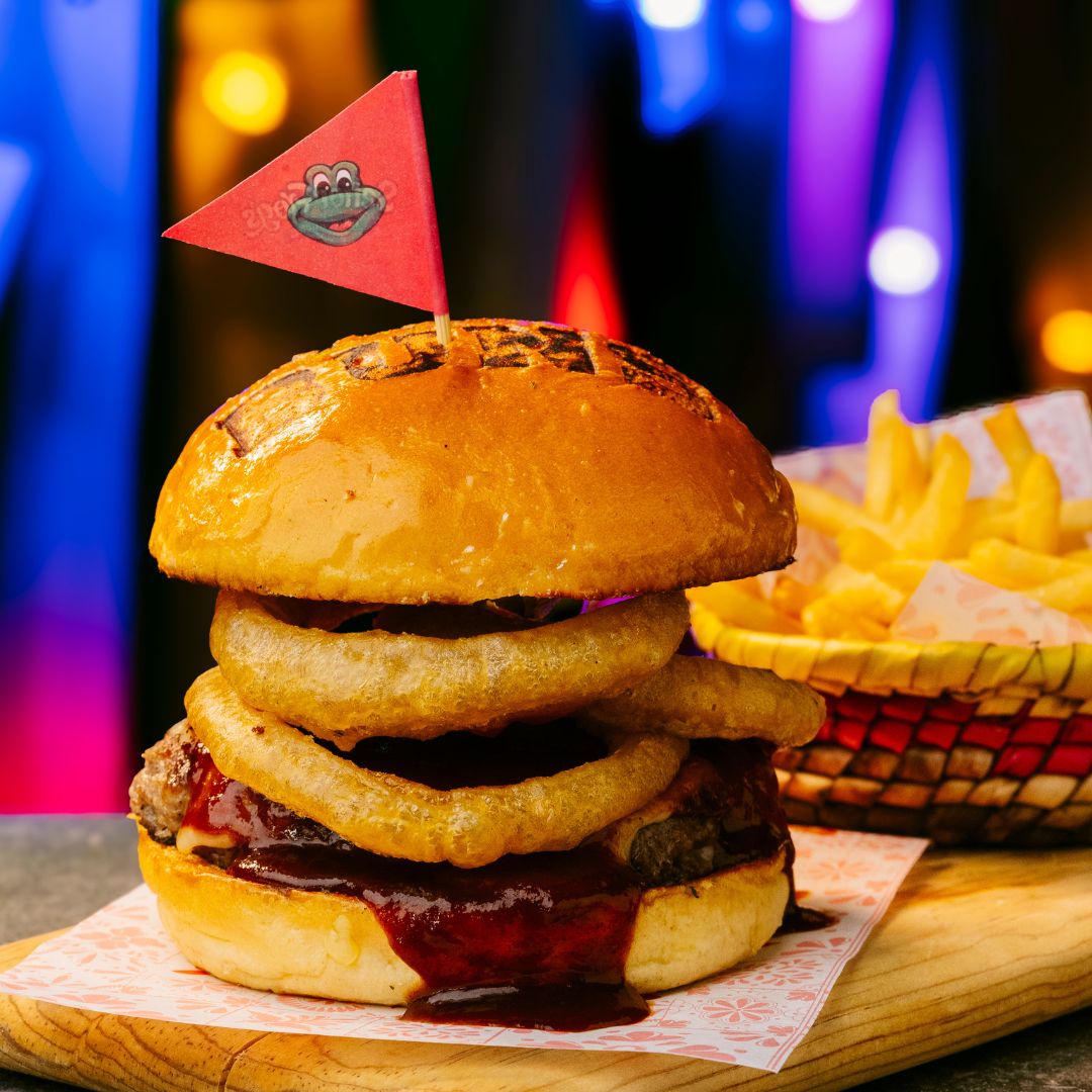 Hamburguesa BBQ crunch con aros de cebolla y papas en Señor Frog’s Playa del Carmen