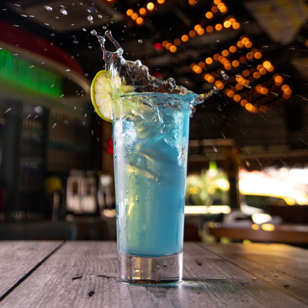 Trago azul salpicando con una rodaja de limón en Señor Frog’s Playa del Carmen