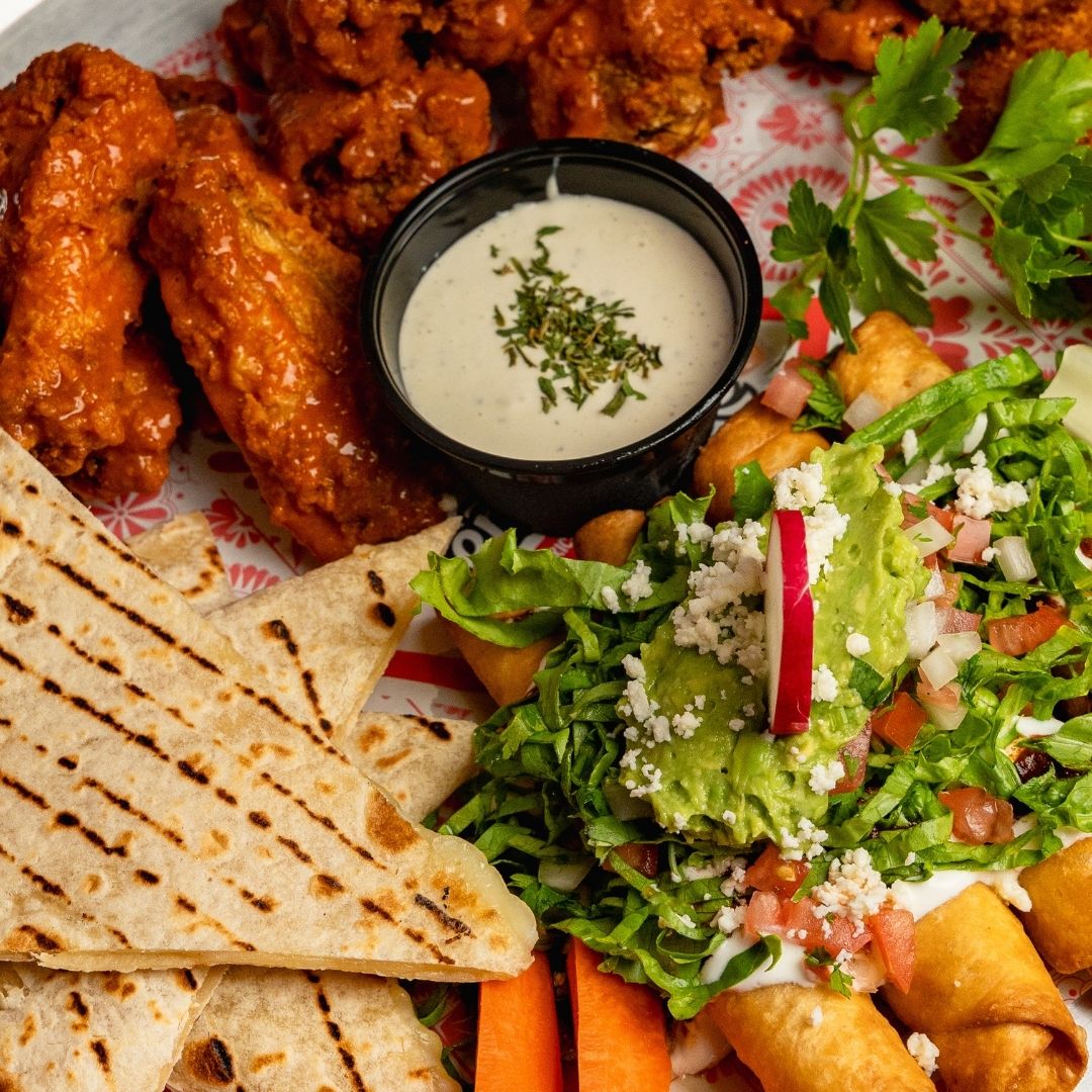 Platón para compartir con alitas búfalo, quesadillas, taquitos y guacamole en Señor Frog’s Playa del Carmen